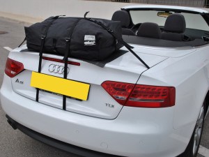 Audi A5 cabriolet blanche avec porte-bagages installé, photographiée à proximité de l'arrière